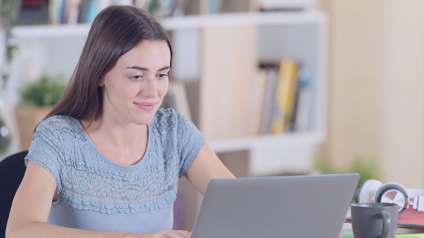 Mulher utilizando o computador para realizar uma inscrição online